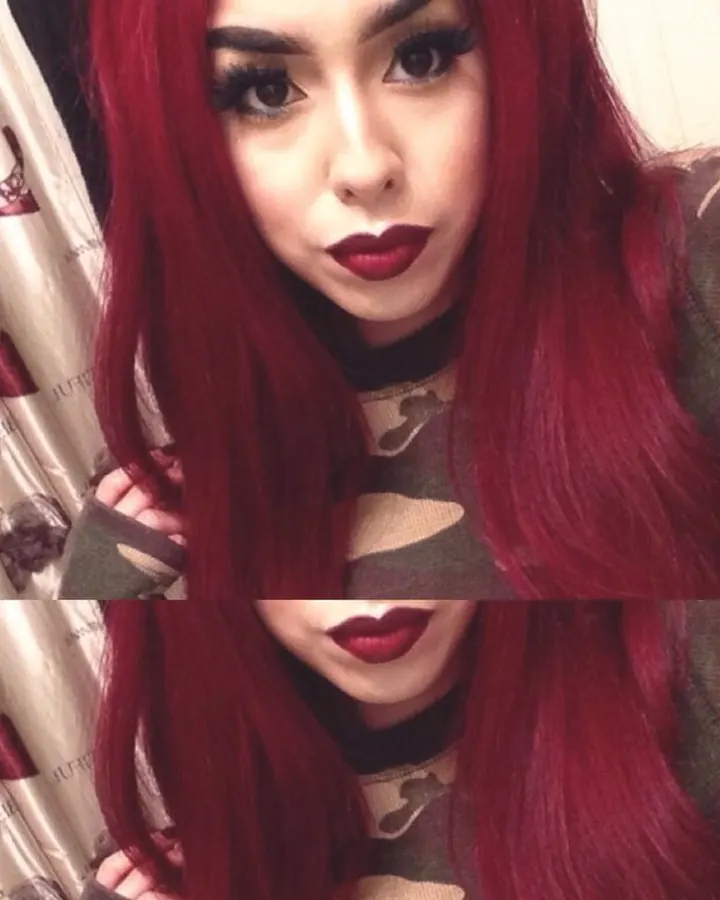 Femme aux cheveux rouges vifs, vêtue d’un haut noir et d’un haut camouflage, prenant un selfie en deux parties, regard fixe et maquillage intense.