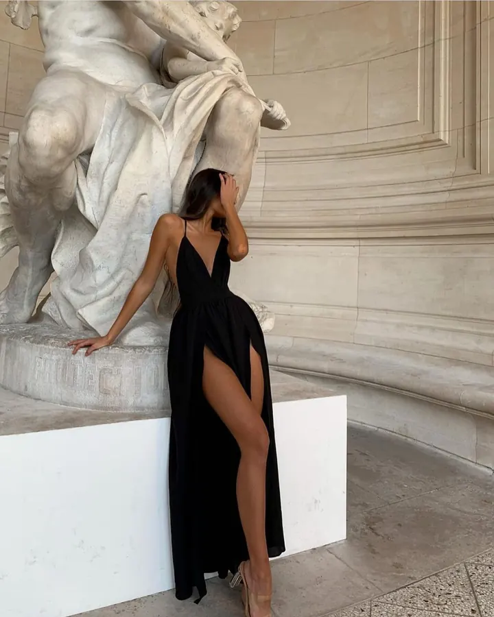 Femme en lingerie noire, vue de dos, avec des chaînes métalliques autour du torse